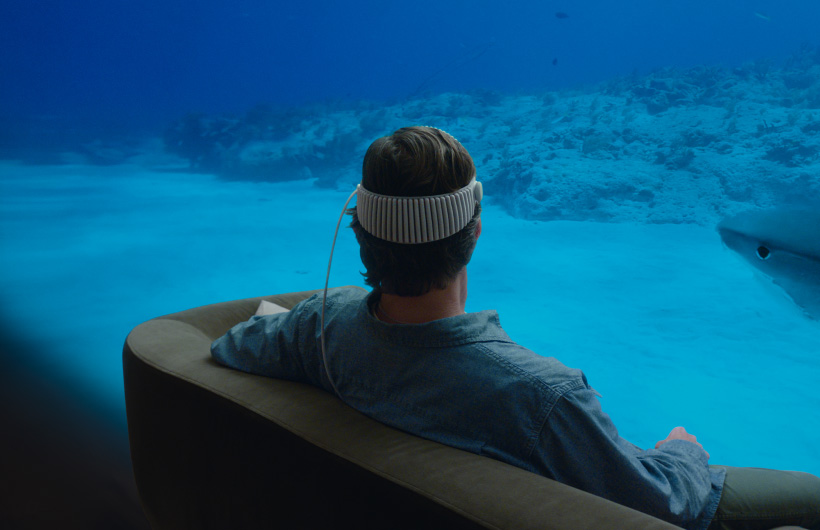 Apple Vision Pro user watches an Apple Immersive Video of a scuba diver interacting with sharks