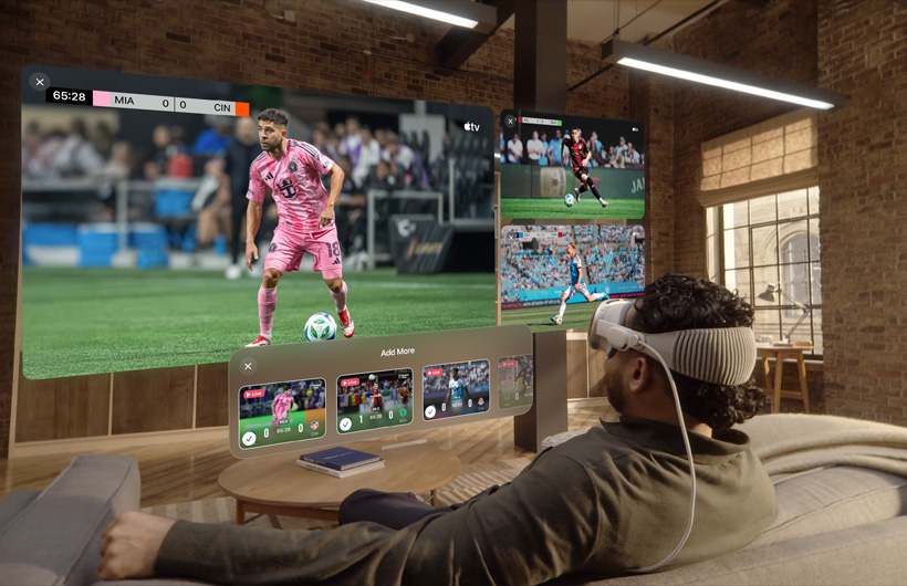 A person watching a large screen alongside two smaller screens showing different sporting events